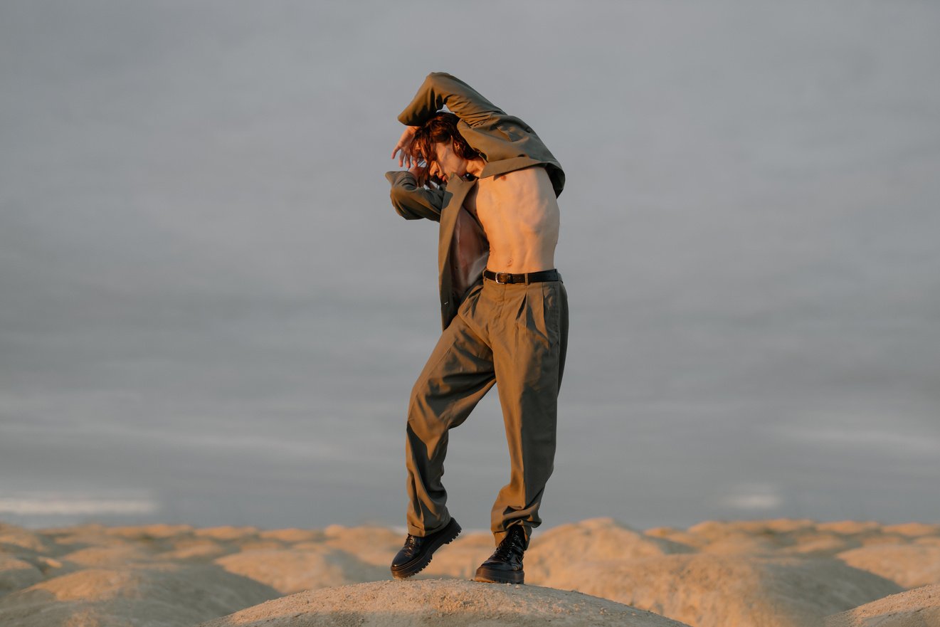 Man in Brown Jacket and Brown Pants Standing on Brown Rock